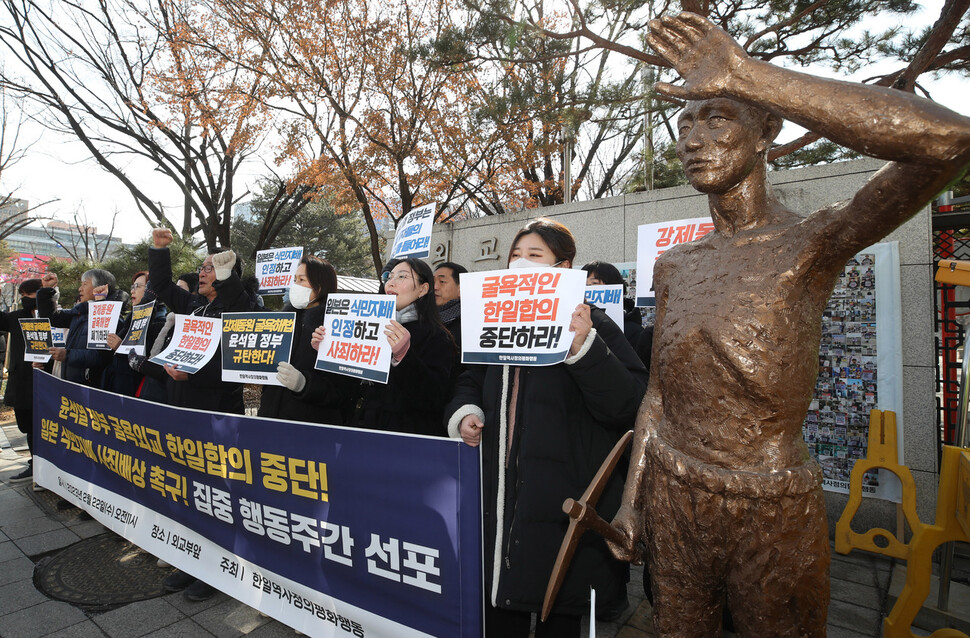 한일역사정의평화행동 회원들이 22일 오전 서울 종로구 외교부 청사 앞에서 기자회견을 열어 일제강점기 강제징용 배상과 관련해 한일 간 협상을 추진 중인 정부를 규탄하며 삼일절까지 남은 일주일을 ‘집중행동주간’으로 선포하며 구호를 외치고 있다. 오른쪽에는 강제동원피해자를 형상화한 동상이 서 있다. 신소영 기자 viator@hani.co.kr