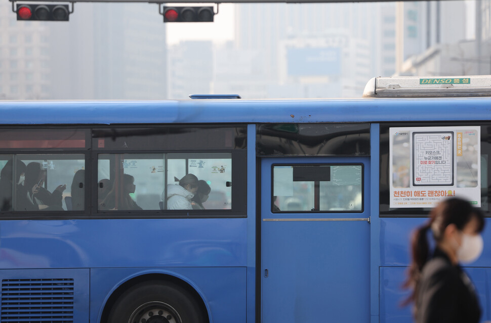 지난 3월20일 오전 서울 광화문광장에서 바라본 시내가 뿌연 가운데 대중교통 마스크 착용 의무 해제 첫날인 이날 마스크를 쓰고 버스에 탄 시민들의 모습. 연합뉴스