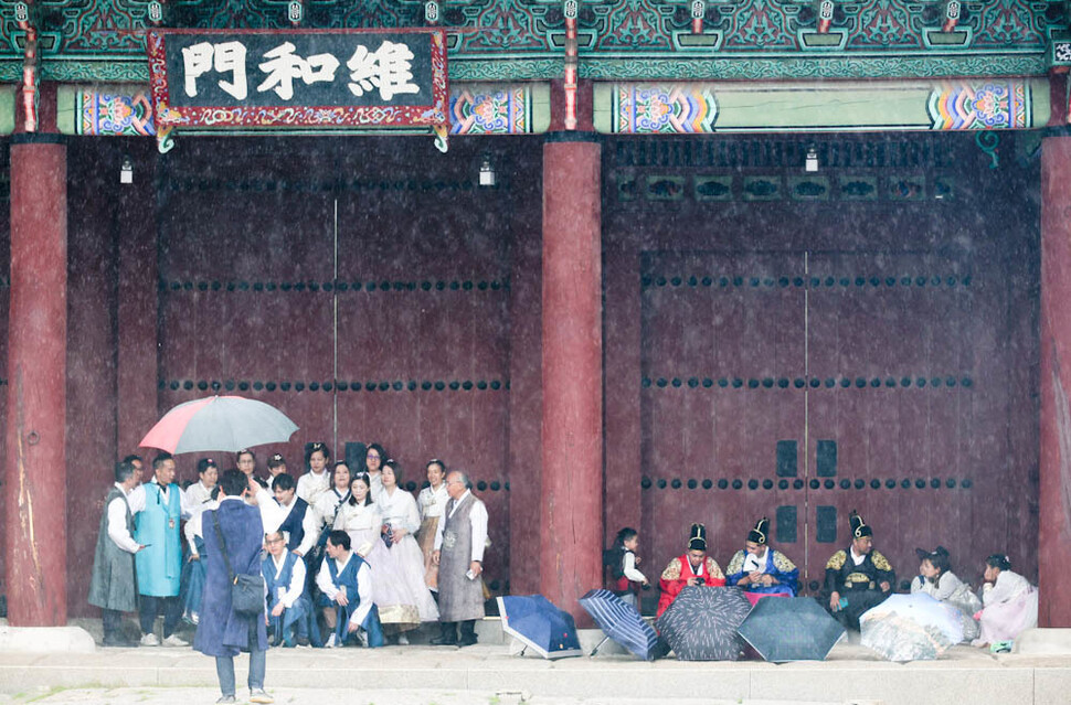 전국 대부분 지역에 비가 내린 28일 오전 서울 종로구 경복궁을 찾은 외국인 관광객들이 처마 밑에서 비를 피하고 있다. 김정효 기자