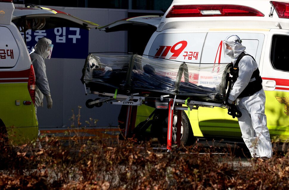 코로나19 위중증 환자가 연일 최다치를 기록하는 가운데 1일 서울 은평구 서울시립서북병원에서 119 구급대원 및 의료진이 확진 환자를 감염 방지용 카트에 실어 옮기고 있다. 연합뉴스