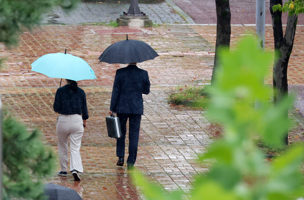 지난 14일 오후 광주 서구 치평동에서 시민들이 내리는 가을비에 우산을 쓰고 걸어가고 있다. 연합뉴스