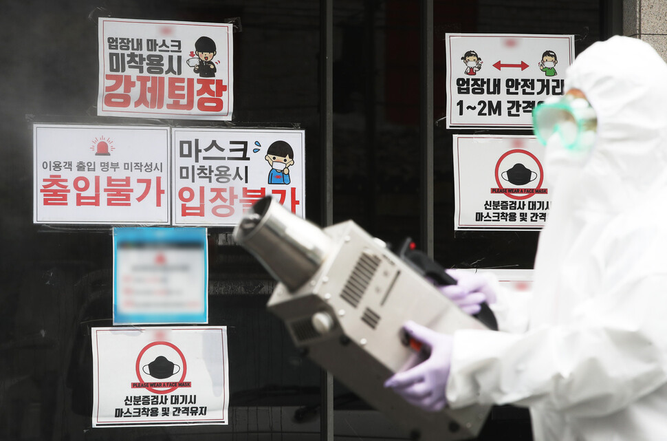 이재명 경기도지사가 도내 모든 유흥시설에 집합금지 행정명령을 발표한 10일 오후 경기도 수원시의 한 클럽 앞에서 보건소 관계자가 코로나19 예방을 위해 방역 작업을 하고 있다. 연합뉴스