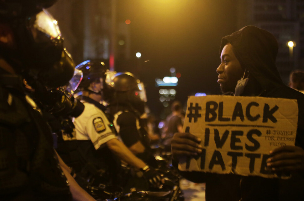 지난달 28일 미국 오하이오주 콜럼버스 시내에서 한 시위자가 조지 플로이드 사망에 항의하는 시위 도중 경찰 앞에서 ‘흑인의 생명은 소중하다’고 적힌 팻말을 들고 있다. AP 연합뉴스