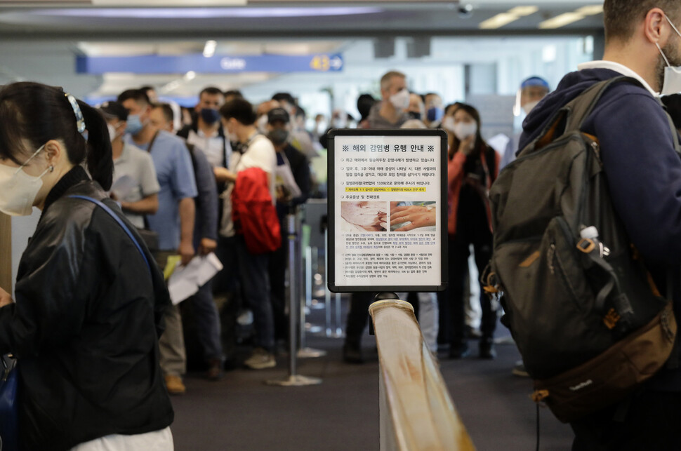 지난 5월27일 오전 인천국제공항 제1 터미널 입국장에 독일 프랑크푸르트와 우즈베키스탄발 탑승객들이 검역을 받기 위해 대기하고 있다. 승객들 앞에는 원숭이두창 관련 안내문이 세워져 있다. 인천공항/김명진 기자 littleprince@hani.co.kr