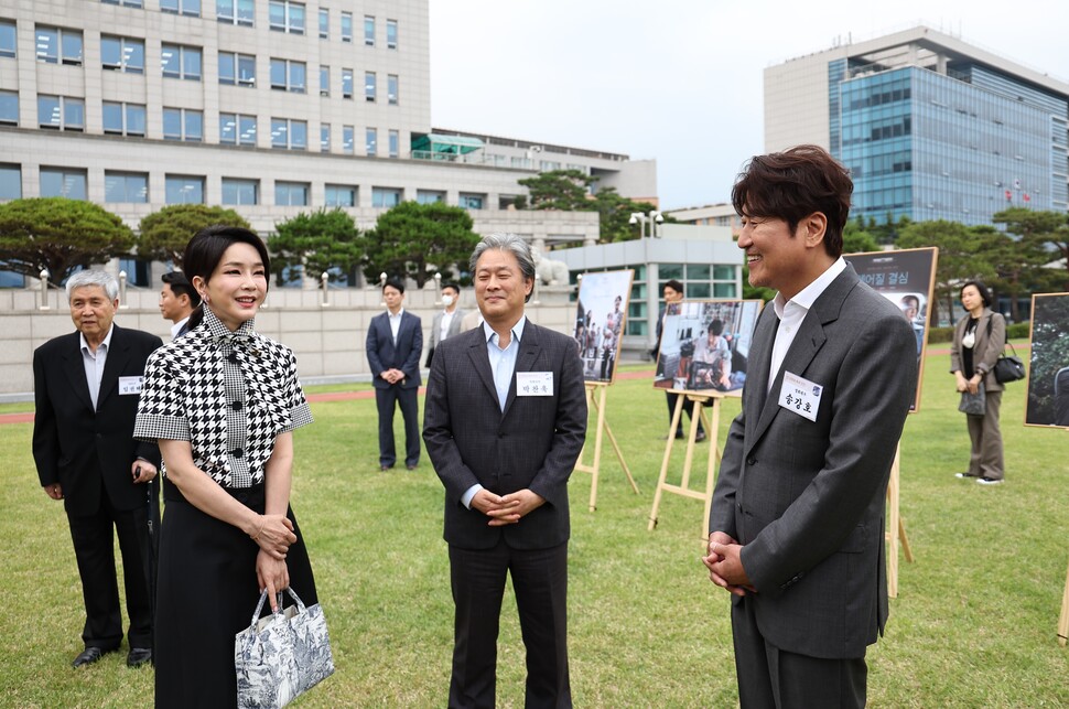 김건희 여사가 12일 오후 서울 용산 대통령실 청사 잔디마당에서 열린 영화관계자 초청 만찬에서 한국 배우 최초로 칸국제영화제에서 남우주연상을 받은 배우 송강호(영화 브로커)와 감독상을 수상한 박찬욱 감독(영화 헤어질 결심)과 대화하고 있다. [대통령실 제공]