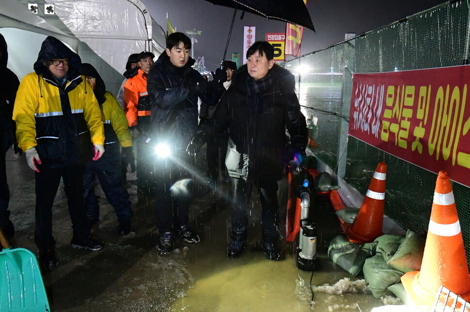 최문순 화천군수(사진 오른쪽)와 관계자들이 폭우가 내린 산천어축제장을 점검하고 있다. 화천군 제공