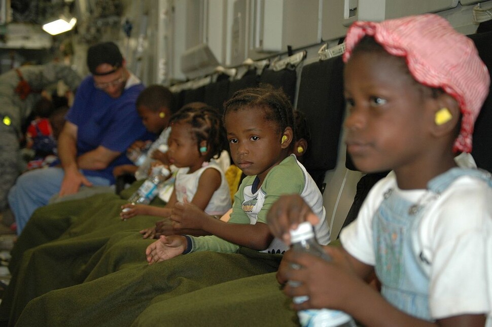 2010년 아이티의 한 고아원에 있던 어린이들이 미국의 새 가정으로 입양되기 위해 미군 수송기 안에 앉아 있다. 위키미디어 코먼스