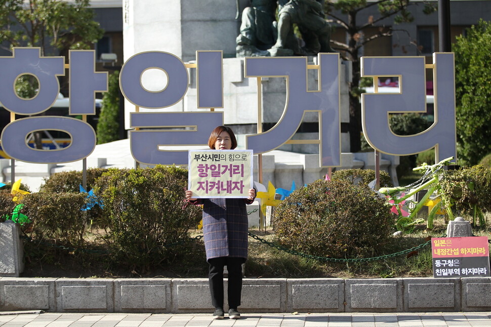 부산 동구 초량동 정발 장군 동상에 세워진 항일거리 현판 앞에서 변정희 부산여성단체연합 상임대표가 항일거리 철거를 반대하는 1인 시위를 하고 있다.