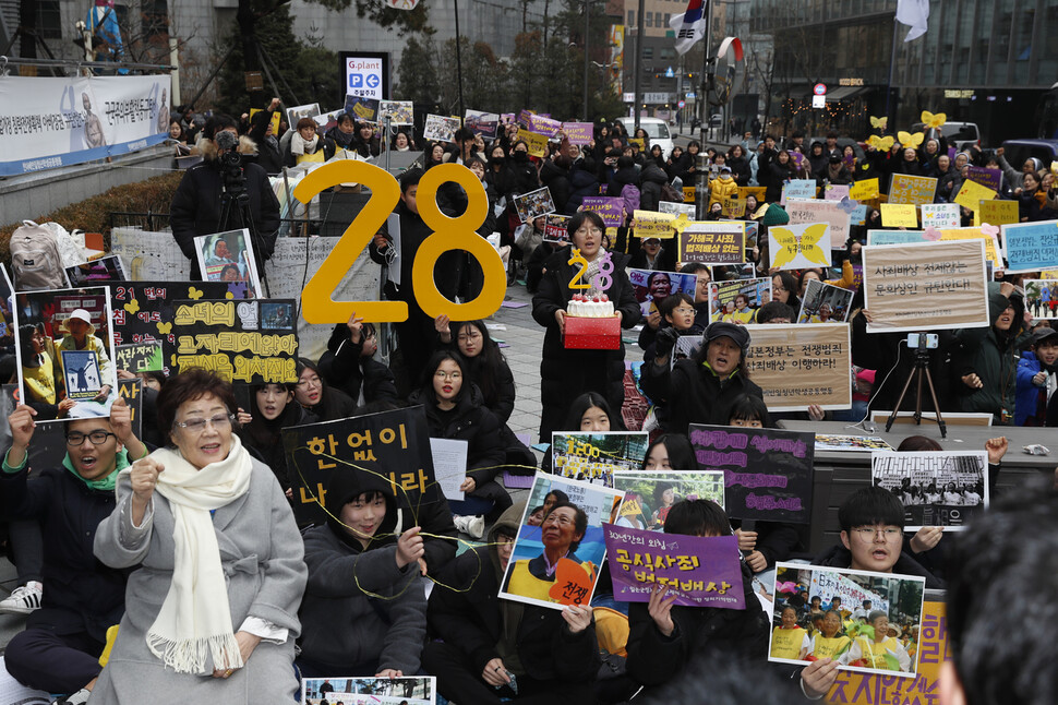 1992년 1월 8일 서울 종로구 중학동 옛 주한일본대사관 앞에서 “일본군성노예제 문제해결을 위한 제1차 수요시위”가 열린 뒤 만 28년이 지났다. 8일 낮 열린 제1421차 수요시위에서 이용수 할머니(앞줄 맨왼쪽)와 참가자들이 그동안 수요시위에 함께 참가한 할머니들의 사진들과 다양한 손팻말을 들어보이며 일본의 공식 사죄를 촉구하고 있다. 이정아 기자 leej@hani.co.kr