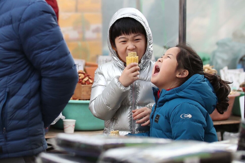 설연휴를 앞둔 19일 오전 경기도 성남 모란시장에서 부모님을 따라 시장구경에 나선 아이들이 옥수수를 먹으며 즐거워 하고 있다. 성남/백소아 기자 thanks@hani.co.kr