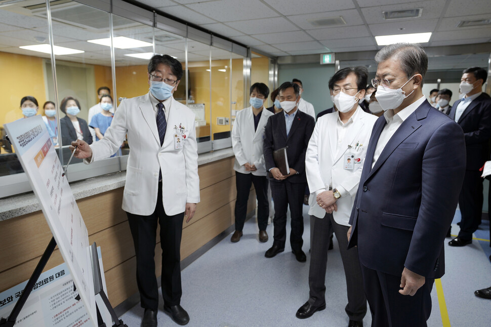 문재인 대통령이 28일 오전 신종 코로나바이러스 감염증 대응 의료기관인 서울 중구 국립중앙의료원에서 고임석 대응TF 팀장의 설명을 듣고 있다. 청와대 제공