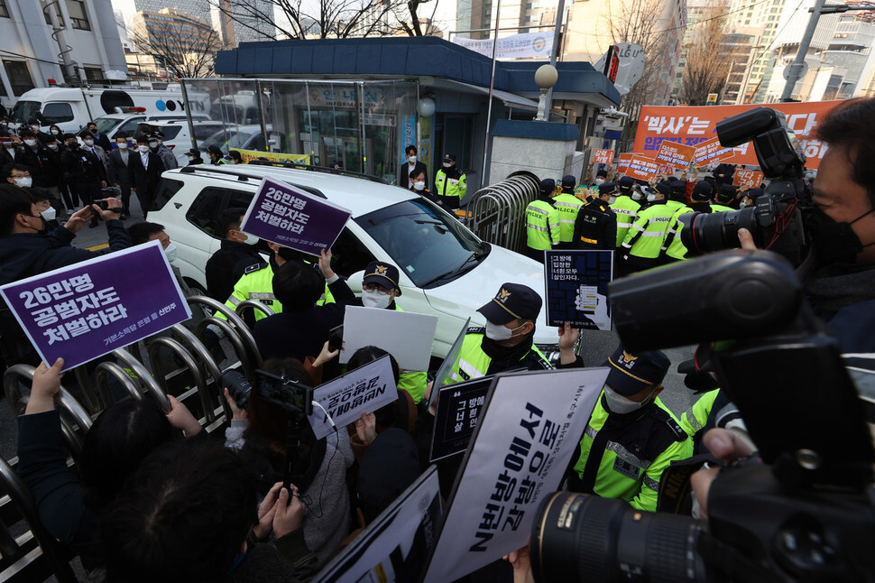 텔레그램에 ‘박사방’을 열고 미성년자를 포함한 여성들을 대상으로 성착취 범죄를 저지른 ‘박사’ 조주빈씨가 탄 차량이 25일 오전 서울중앙지검으로 조씨를 송치하기 위해 서울 종로경찰서를 나서자, 시민들이 조씨의 강력 처벌을 요구하는 손팻말을 들고 시위를 하고 있다. 공동취재사진