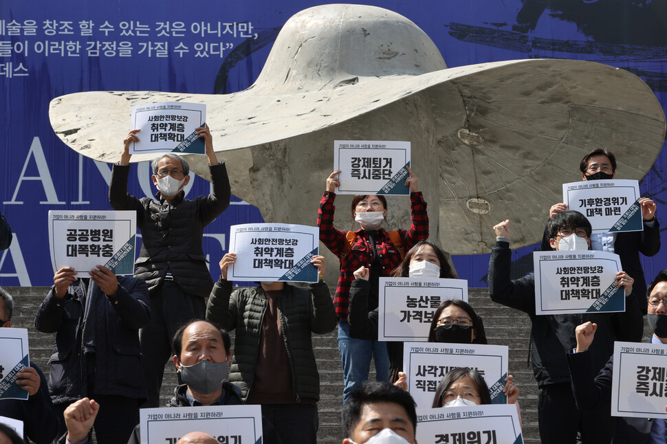 종교·시민사회단체가 31일 오후 1시 서울 종로구 세종문화회관 계단에서 연 `코로나19 경제 사회 위기 대응 관련 입장 발표 기자회견'에서 참가자들이 구호를 외치고 있다. 이정아 기자 leej@hani.co.kr