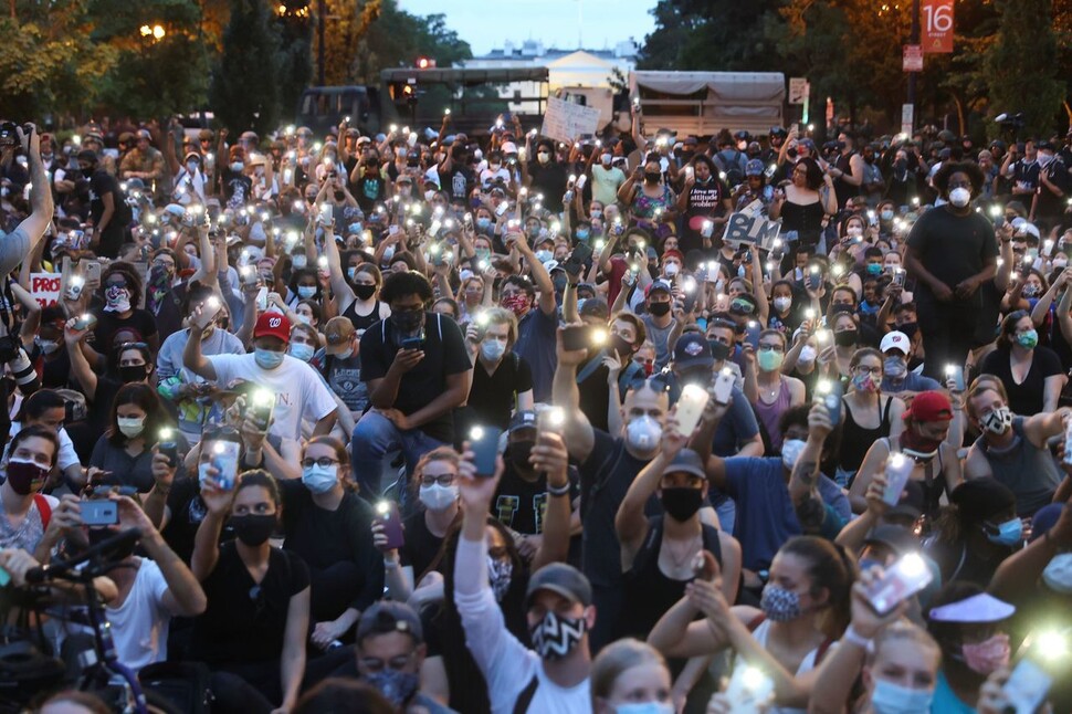 미국 워싱턴 백악관 근처에서 지난 3일(현지시각) 흑인 조지 플로이드의 사망에 항의하는 수많은 시민이 휴대전화 전등 시위를 하고 있다. 워싱턴/로이터 연합뉴스