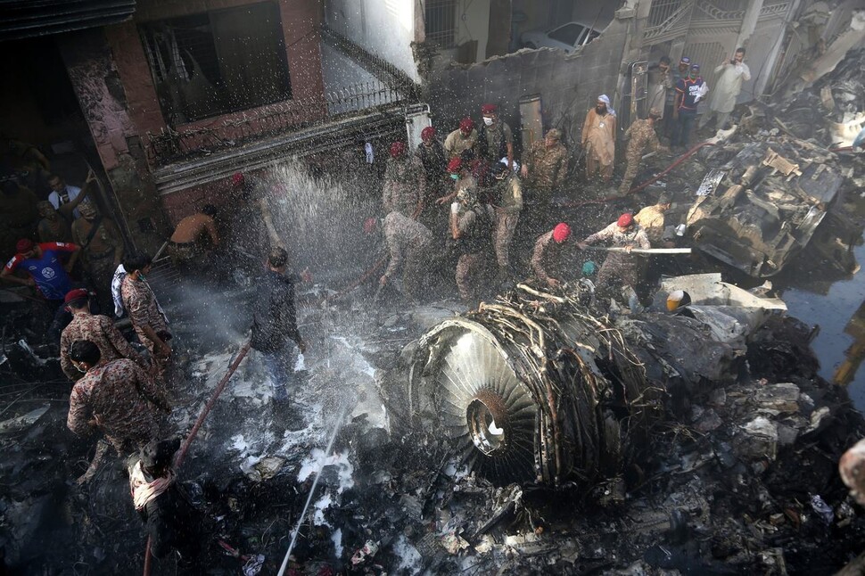 5월22일 파키스탄 남부 카라치의 여객기 추락사고 현장에서 의용 구조대원들이 생존자를 찾고 있다. 카라치/AP연합뉴스