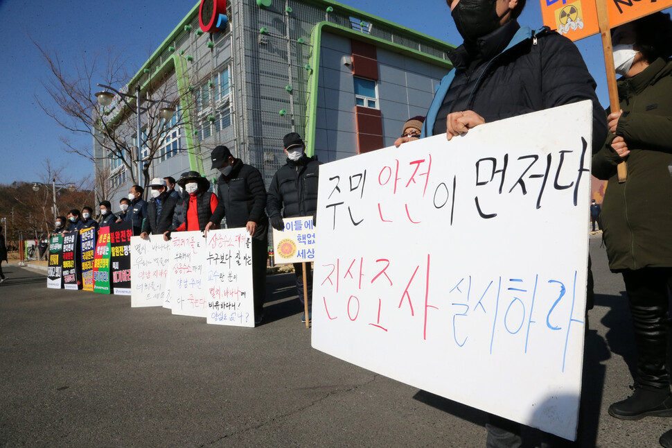 지난 14일 경북 경주 월성원자력본부 홍보관 앞에서 국민의힘 국회의원단 긴급 방문에 맞춰 일부 경주 양남면민이 삼중수소 검출에 항의하는 팻말을 들고 서 있다. 연합뉴스