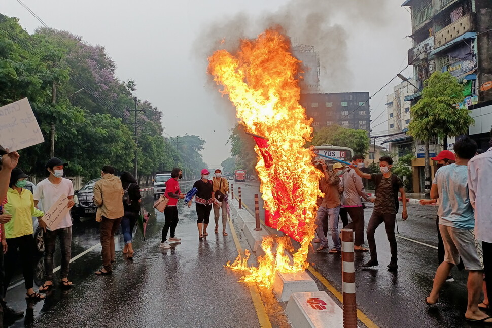 5일(현지시간) 미얀마 최대 도시 양곤에서 군부 쿠데타에 반대하는 시위대가 중국 오성홍기를 불태우고 있다. 연합뉴스