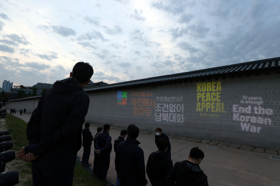 경복궁 관계자들이 허가 문제로 한반도 종전 평화 캠페인 주최로 열린 ‘판문점선언 3년 맞이 광화문 조명 프로젝션’ 행위극을 막고 있다. 연합뉴스