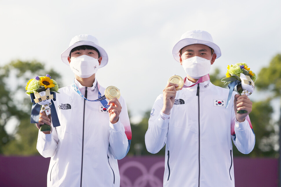 양궁 국가대표 김제덕(오른쪽)과 안산이 24일 일본 도쿄 유메노시마 공원 양궁장에서 열린 도쿄올림픽 혼성 결승전에서 금메달을 목에 걸고 포즈를 취하고 있다. 도쿄/연합뉴스