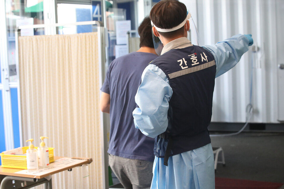 30일 오후 서울 코로나19 동작구보건소 선별진료소에서 얼음조끼를 입은 의료진이 시민을 안내하고 있다. 연합뉴스. 30일 오후 서울 코로나19 동작구보건소 선별진료소에서 얼음조끼를 입은 의료진이 시민을 안내하고 있다. 연합뉴스.