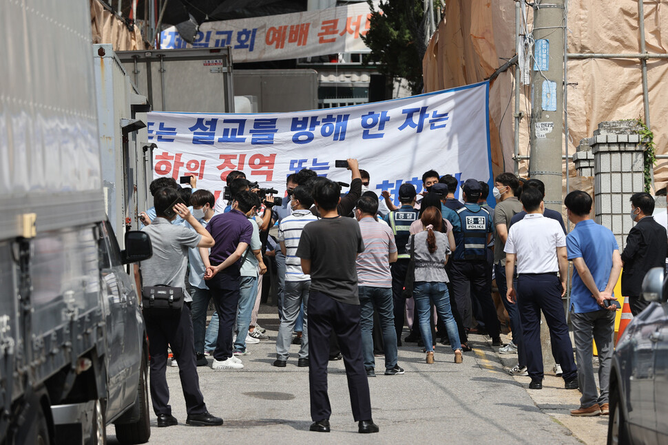 8일 오전 서울 성북구 사랑제일교회 인근에서 교회 방역수칙 준수 여부를 점검하러 온 성북구청 관계자들을 막아선 교회 측 변호인단 및 관계자들이 언쟁하고 있다. 사랑제일교회는 방역 당국으로부터 대면예배 금지 명령을 받고도 이를 여러 차례 위반해 성북구로부터 운영 중단 명령 처분을 받은 바 있다. 중앙재난안전대책본부는 지난 6일 현행 사회적 거리두기 단계(수도권 4단계·비수도권 3단계)를 2주간 연장하면서도 종교시설의 경우 수용인원 100명 이하는 10명, 수용인원 101명 이상은 10%까지 대면 종교활동을 허용하되 최대 99명까지 할 수 있도록 참석 제한을 완화했다. 연합뉴스