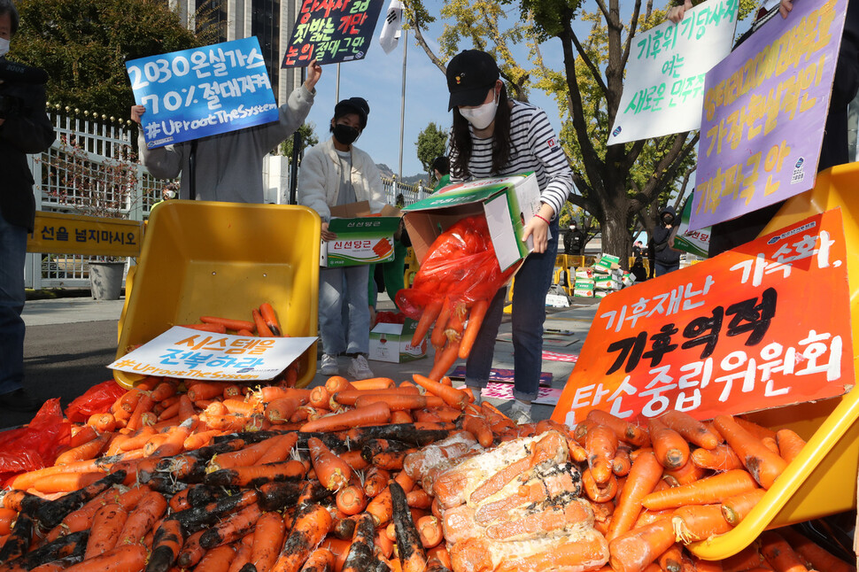 ‘1022 글로벌 기후파업행동’ 참석자들이 22일 오전 서울 광화문 정부서울청사 앞에서 정부의 기후위기 대응의 부당함을 알리기 위해 436kg의 당근을 쏟는 행위극을 벌이고 있다. 김태형 기자 xogud555@hani.co.kr