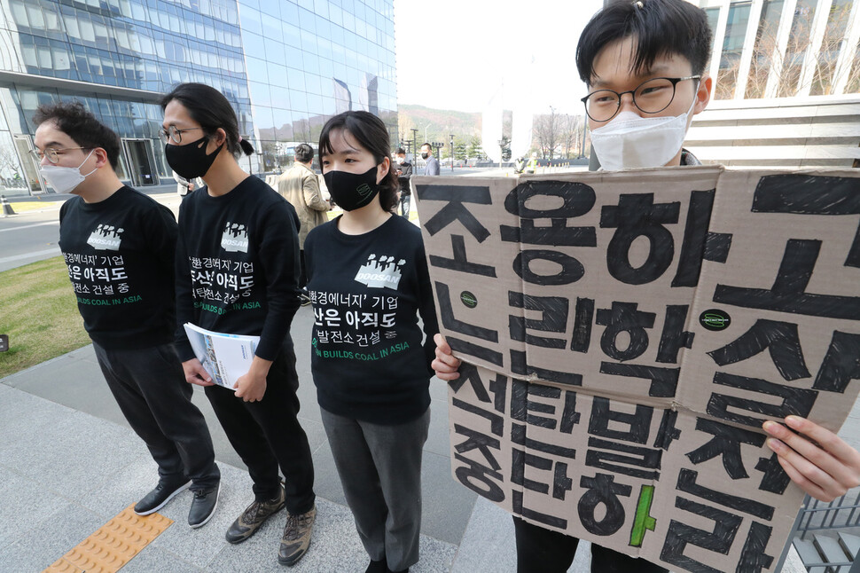 두산중공업 주주총회가 열린 29일 오전 경기 성남시 분당두산타워 앞에서 청년기후긴급행동 활동가들이 두산중공업의 해외 석탄발전소 건설 사업 중단 등을 촉구하고 있다. 김태형 기자 xogud555@hani.co.kr