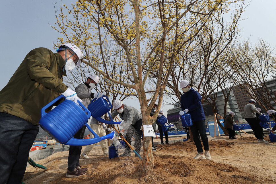 식목일인 5일 오전 서울 광화문 세종로공원 앞 사계정원에서 ‘새로운 광화문 광장 수목 식재 행사’가 열려 참가자들이 함께 산수유 나무를 심은 뒤 물을 주고 있다. 신소영 기자 viator@hani.co.kr