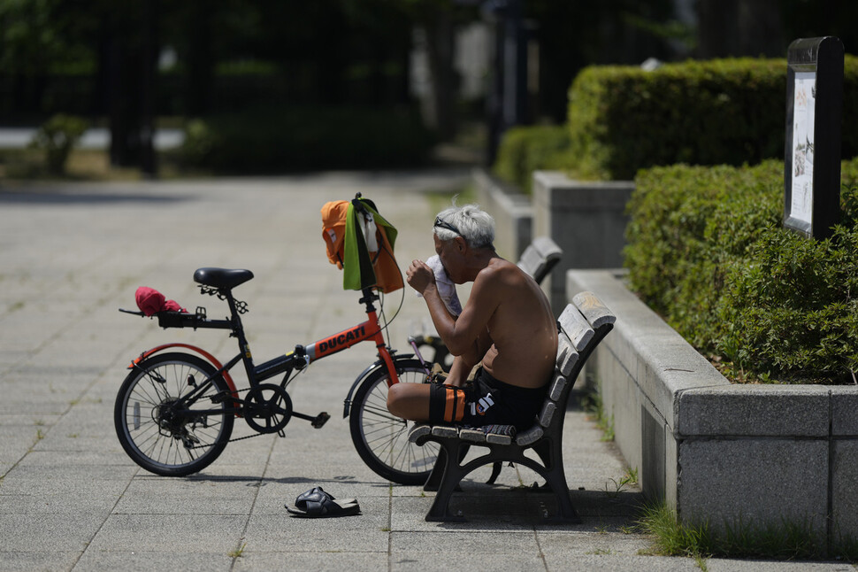 지난달 27일 일본 도쿄의 한 공원에서 자전거 운전자가 폭염 속에 휴식을 취하며 얼굴의 땀을 닦아내고 있다. 도쿄에서는 최근 연이은 폭염으로 52명이 열사병으로 사망한 것으로 추정되고 있다. 연합뉴스