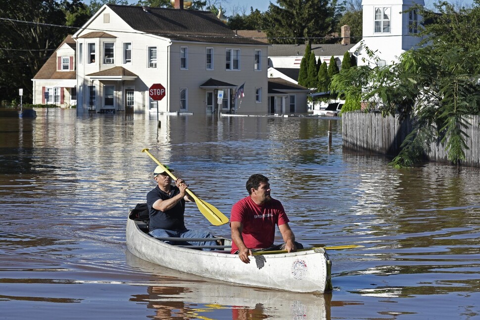 2021년 9월2일(현지시각) 허리케인 ‘아이다’가 동반한 기록적인 폭우로 홍수가 발생한 미국 뉴저지주 맨빌의 주택가에서 주민들이 카누를 타고 이동하고 있다. 연합뉴스