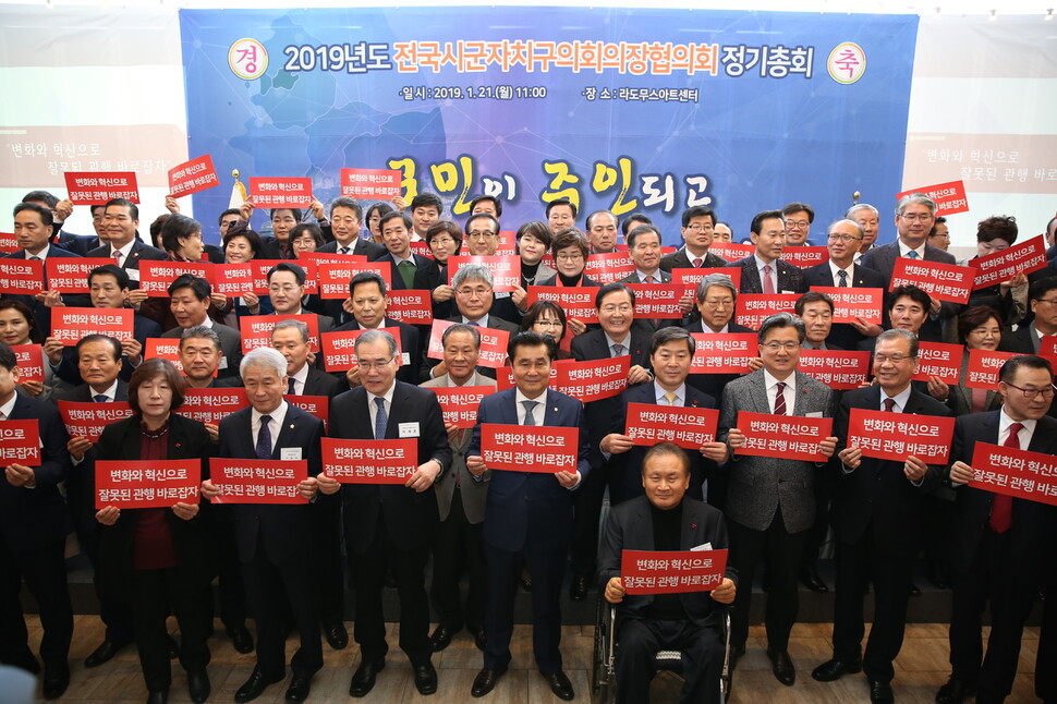 대한민국시군자치구의회의장협의회 참석자들이 2019년 열린 정기총회에서 “변화와 혁신으로 잘못된 관행을 바로잡자”는 문구가 적힌 손팻말을 들고 외유성 해외연수를 하지 않겠다고 약속하고 있다. 대한민국시군자치구의회의장협의회 제공