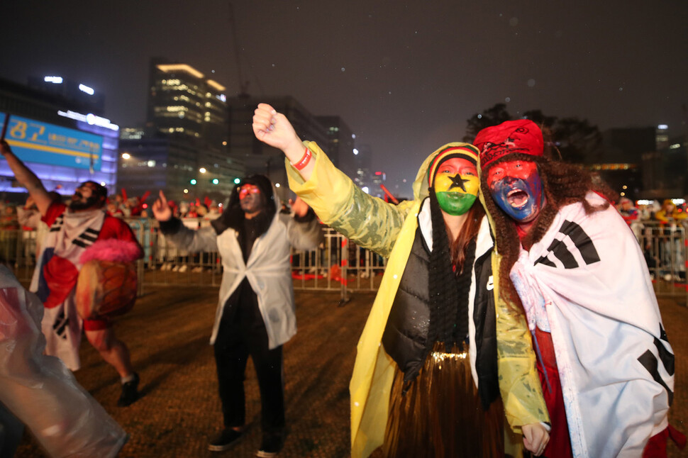 한국과 가나의 2022 카타르월드컵 H조 2차전이 열리는 28일 밤 서울 광화문광장에서 태극기와 가나 국기로 페이스페인팅을 하고 나온 시민들이 양국 선수들의 선전을 응원하고 있다. 백소아 기자 thanks@hani.co.kr