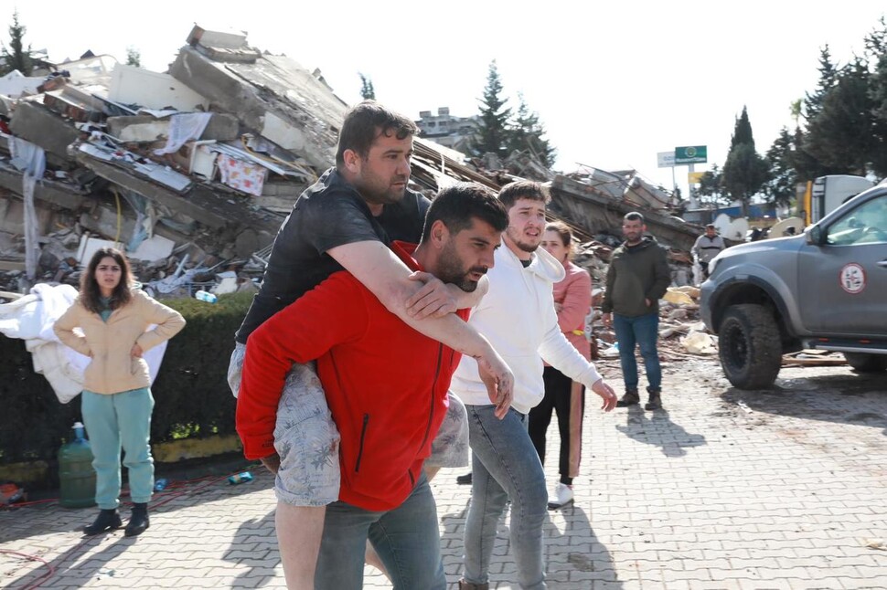 7일(현지시각) 튀르키예 하타이의 지진 피해 지역에서 구조대원들이 부상자를 업어 대피시키고 있다. 하타이/UPI 연합뉴스