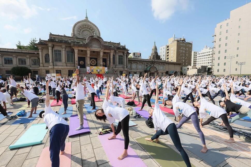 21일 일본 도쿄 츠키지 홍간지 경내에서 세계 요가의 날을 기념하기 위해 650여명의 사람들이 수련하고 있다. AFP 연합뉴스