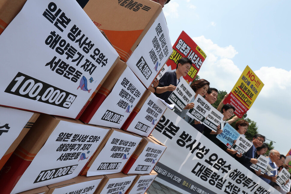 18일 오전 서울 용산구 대통령실 앞에서 열린 일본 방사성오염수 해양투기반대 서명용지 전달 야4당-시민사회 공동 기자회견에서 참가자들이 손팻말을 들고 있다. 백소아 기자 thanks@hani.co.kr