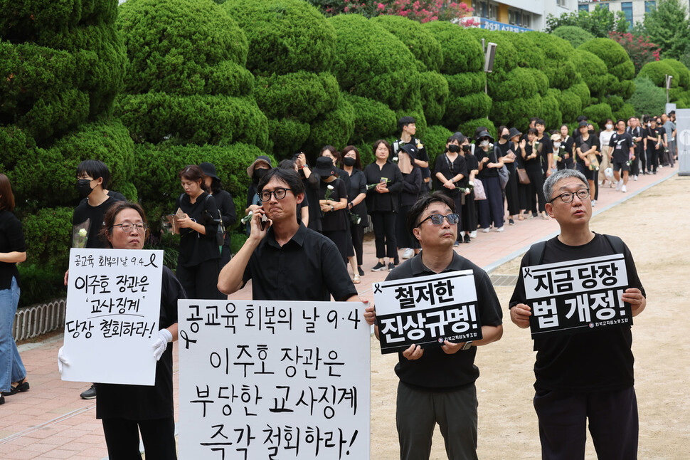 지난 7월 19일 서울 서초구의 한 초등학교에서 세상을 등진 교사의 49재인 4일 오전 추모제가 열린 강당 앞에서 교사들이 이주호 장관을 규탄하는 팻말을 들고 서 있다. 백소아 기자 thanks@hani.co.kr