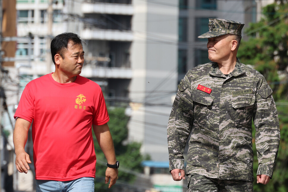 항명과 이종섭 국방부 장관에 대한 ‘상관 명예훼손’ 혐의를 받고 있는 박정훈 전 해병대 수사단장(대령)이 5일 서울 용산구 국방부 검찰단으로 출석하던 중 해병대 예비역 동기생과 마주보며 미소짓고 있다. 김혜윤 기자 unique@hani.co.kr