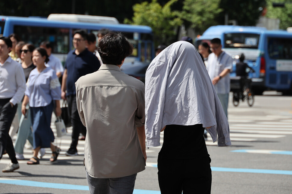 전국 대부분 지역의 낮 최고기온이 30도를 넘은 6일 낮 서울 종로구 광화문네거리에서 셔츠를 뒤집어쓴 한 시민이 길을 건너고 있다. 김혜윤 기자 unique@hani.co.kr