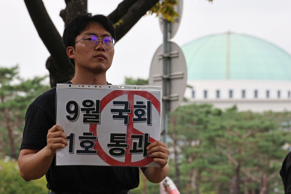 16일 오후 서울지하철 9호선 국회의사당역 인근에서 열린 ‘공교육 회복을 위한 국회 입법 촉구 집회’ 참석자가 손팻말을 들고 현직 초등학교 교사의 발언을 듣고 있다. 김혜윤 기자 unique@hani.co.kr