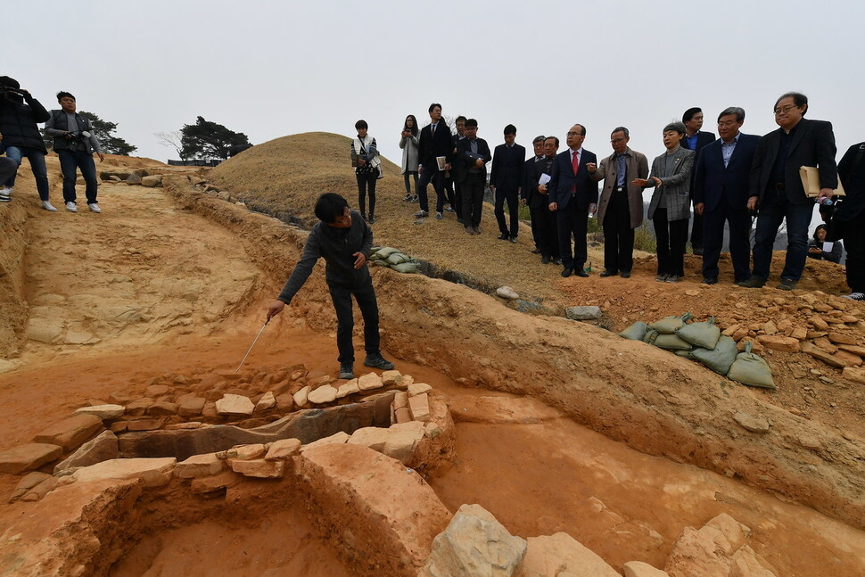 지난 20일 열린 경북 고령 지산동 고분군 발굴 현장 설명회. 흙구슬이 나온 작은 석곽묘를 조사원이 가리키며 설명하고 있다.