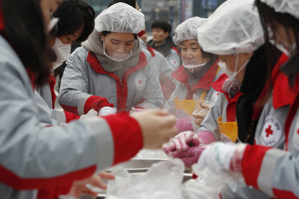 대한적십자사가 2일 오전 시무식을 겸해 새해 떡국 나눔 행사를 연 서울역 광장에서 봉사원들이 떡국과 함께 나눠줄 주먹밥을 만들고 있다. 대한적집자사의 자원봉사자는 약 31만명에 이른다. 이정아 기자