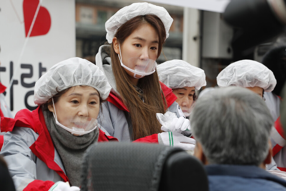 대한적십자사 홍보대사로 활동중인 가수 소유(왼쪽 둘째)가 2일 서울역에서 열린 새해 떡국 나눔 행사에 참가해 음식을 담아주고 있다. 이정아 기자