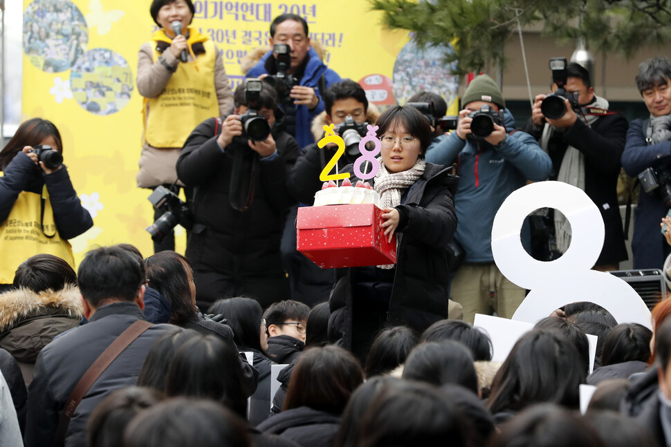 8일 낮 열린 제1421차 수요시위에서 한 참가자가 준비한 수요시위 28주년 기념 케이크를 들어보이고 있다. 이정아 기자