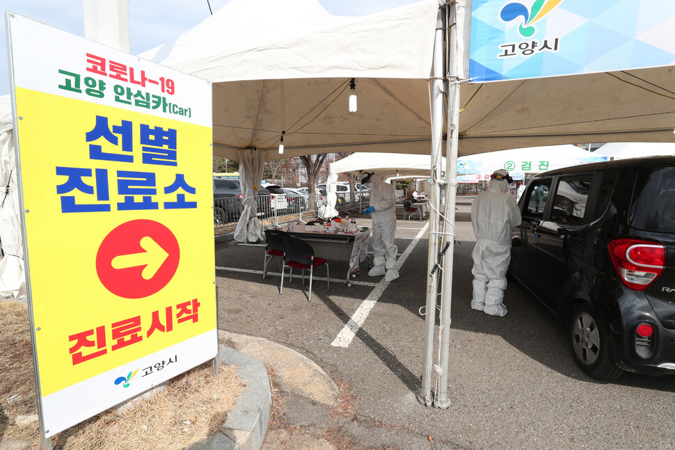 26일 덕양구 주교 제1공용주차장에서 운영을 시작한 ’고양 안심카 선별진료소’에서 의료진이 차량에 탑승한 시민의 체온을 재고 있다.  고양/김정효 기자