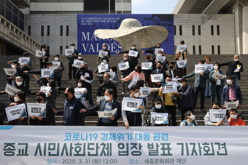 종교·시민사회단체가 31일 오후 서울 종로구 세종문화회관 계단에서 연 `코로나19 경제 사회 위기 대응 관련 입장 발표 기자회견'에서 참가자들이 물리적 거리두기를 위해 한 팔을 벌려 간격을 조정하고 있다. 이정아 기자