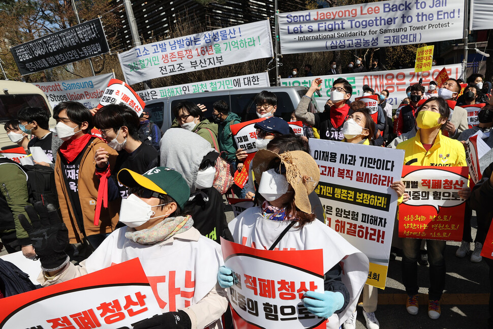 삼성 해고노동자 김용희 씨가 고공농성 300일째인 4일 오후 삼성전자 서초사옥이 있는 서울 강남역 사거리 교통 폐회로텔레비전(CCTV) 철탑 위에서 건강 상태를 살피기 위해 사다리차를 타고 올라온 연대자 대표들과 대화하는 모습을 참가자들이 지켜보고 있다. 이정아 기자