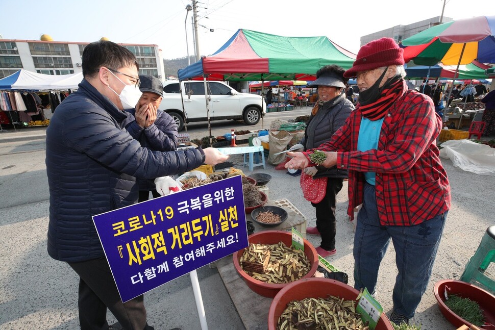 전남 진도군청 직원들이 7일 오전 읍내 5일장터인 조금시장에서 코로나19 감염 예방을 위한 사회적 거리두기 홍보와 상인들에게 마스크를 나눠주고 있다. 진도/김봉규 선임기자 bong9@hani.co.kr