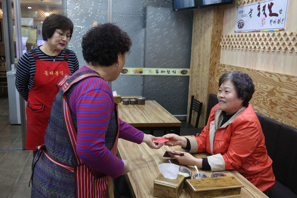 전주 시민 한미 오씨 (오른쪽) 가 지난 22 일 오후 전주 남부 시장 안 식당 을 찾아 전주시 가 지급 한 재난 기본 소득 카드 로 음식 값 을 치를 수 있는지 물어 보고 있다. 장철규 선임 기자 chang21@hani.co.kr