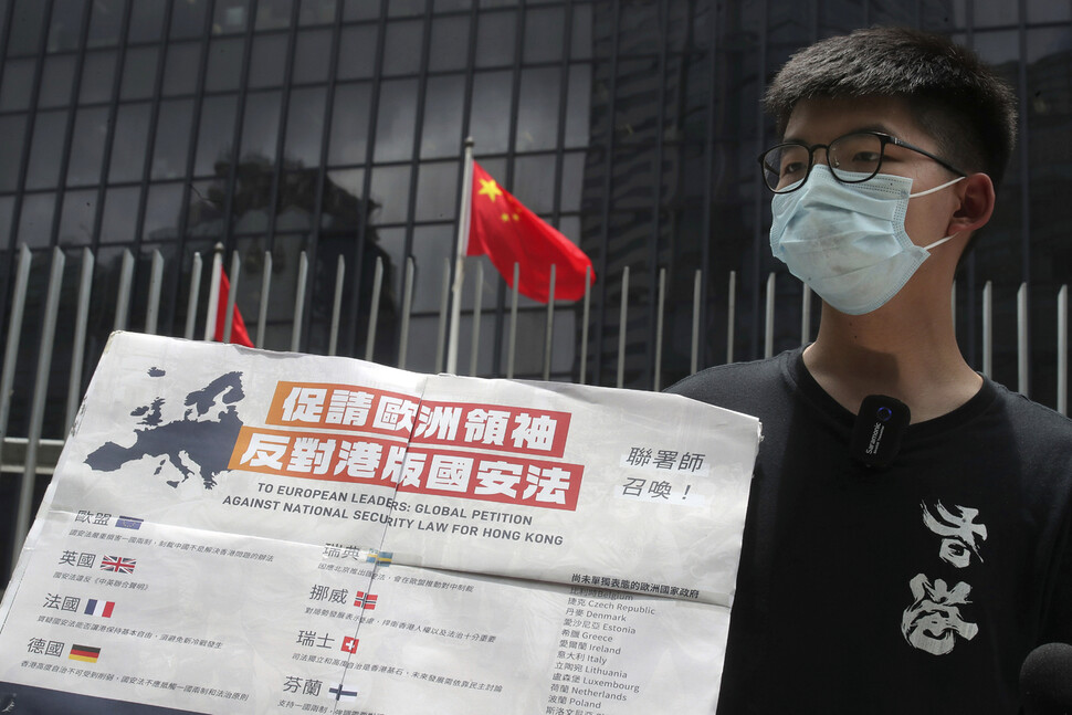 조슈아 웡 홍콩 데모시스토당 비서장이 3일 홍콩 입법회 앞에서 유럽 지도자들에게 홍콩 국가보안법 반대를 촉구하는 펼침막을 들고 언론과 대화하고 있다. 홍콩/AP 연합뉴스