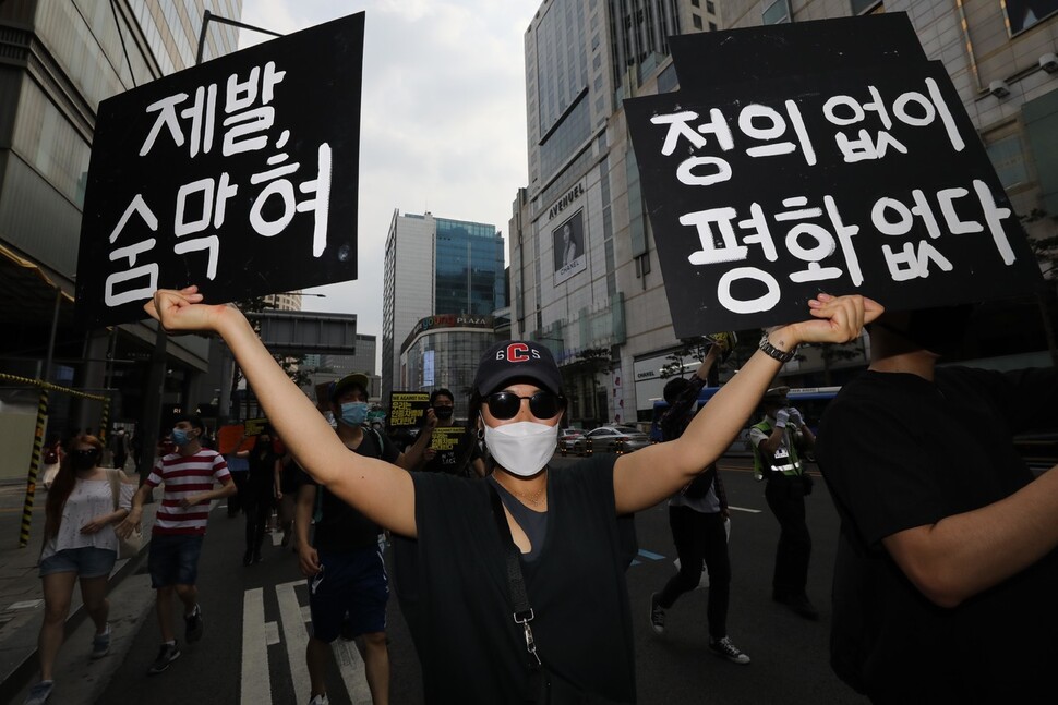 백인 경찰의 과잉 진압으로 숨진 흑인 조지 플로이드씨를 추모하는 행진이 열린 ?6일 오후 서울 명동에서 참가자들이 추모 글귀의 손팻말을 들고 청계천 한빛광장까지 걸어가고 있다. 김봉규 선임기자